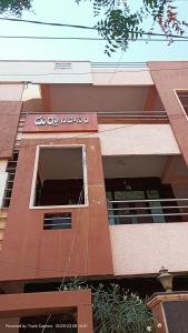 a building with an open door with a window at Durga Nivas in Kurnool