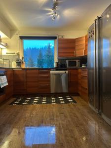 a kitchen with wooden cabinets and stainless steel appliances at Charmigt hus uthyres in Holsljunga