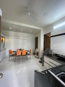 a kitchen and dining room with a table and chairs at Myra Villa Kolhapur Entire Private Home in Kolhapur