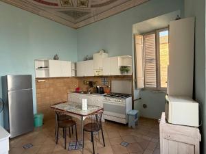 a kitchen with a table and a stove and refrigerator at B&B Falconi in Fermo