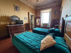 a bedroom with two green beds and a dresser at B&B Falconi in Fermo