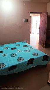 a bed in a room with a blue blanket on it at Durga Nivas in Kurnool +3 photos