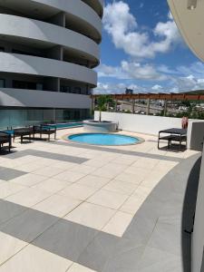 a large building with a swimming pool and benches at Sky Garden Appartement in Quatre Bornes