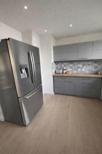a kitchen with a large stainless steel refrigerator at L'entracte in Clairvaux-les-Lacs