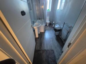 a small bathroom with a sink and a toilet at Cosy and Bright 3-bedroom flat in Glasgow