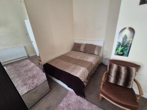 a small bedroom with a bed and a chair at Cosy and Bright 3-bedroom flat in Glasgow +20 photos
