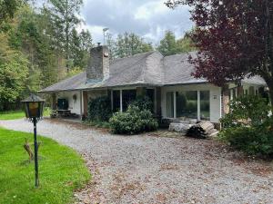 a house with a gravel driveway in front of it at Pré du Tour in Érezée