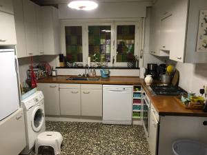 a kitchen with white cabinets and a washer and dryer at Pré du Tour in Érezée