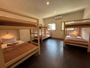 a room with three bunk beds and a window at Lazy Garden Hostel in Phra Ae beach