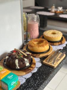 three different types of cakes on plates on a counter at Pousada Preocupacao Zero in Ubajara