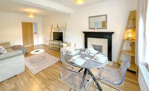 a living room with a table and a fireplace at Pleasant View Cottage in Trehafod