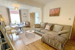 a living room with a couch and a table at Pleasant View Cottage in Trehafod