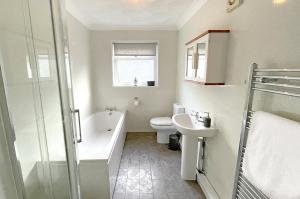 a bathroom with a tub and a toilet and a sink at Pleasant View Cottage in Trehafod +20 photos