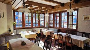 a restaurant with tables and chairs and windows at Gästehaus König in Weinstadt