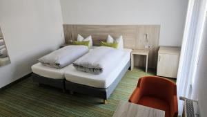 a hotel room with a bed and a chair at Gästehaus König in Weinstadt
