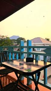 a table on a balcony with a blue bench at west water hostel in Ban Khouaphan