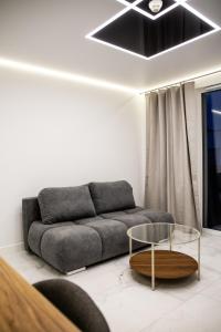 a living room with a couch and a glass table at Luksusowy Apartament W Centrum Gdańska in Gdańsk