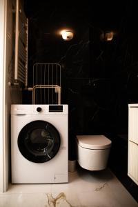 a washing machine in a bathroom with a toilet at Luksusowy Apartament W Centrum Gdańska in Gdańsk