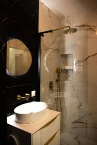 a bathroom with a sink and a glass shower at Luksusowy Apartament W Centrum Gdańska in Gdańsk