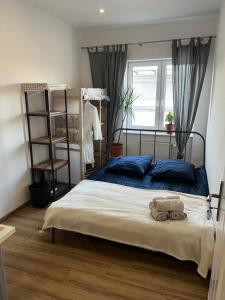 a bedroom with a bed with blue pillows and a window at Million Gold Gdańsk in Gdańsk