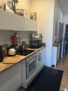a kitchen with white cabinets and a stove top oven at Million Gold Gdańsk in Gdańsk