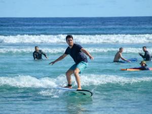 a man riding a wave on a surfboard in the ocean at The Sandscape Fuvahmulah in Fuvahmulah +48 photos