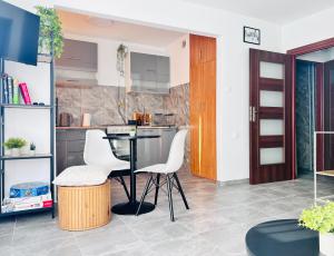 a kitchen with a table and two white chairs at Sunset Studio in Kwidzyn +5 photos