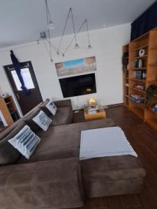 a living room with a brown couch and a flat screen tv at Hei un Urlaub in Neu Damerow +4 photos