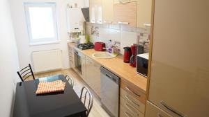 a kitchen with a counter and a table and a sink at Apartament 2 camere SIBIU-SELIMBAR in Şelimbăr +28 photos