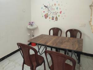 a dining room table with four chairs and a sink at SRI PADMAVATHI NiVAS in Pithāpuram