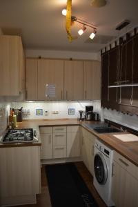 a kitchen with wooden cabinets and a washer and dryer at Hei un Urlaub in Neu Damerow