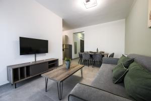 a living room with a couch and a flat screen tv at Antheon Suites Volos in Volos