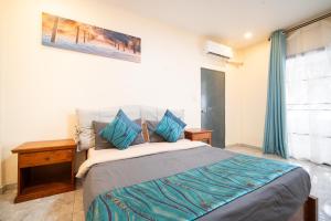 a bedroom with a large bed with blue pillows at NO 7 Garden Villa in Rawai Beach