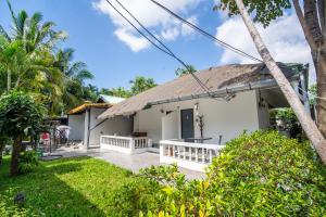 a small white house with a thatched roof at NO 7 Garden Villa in Rawai Beach