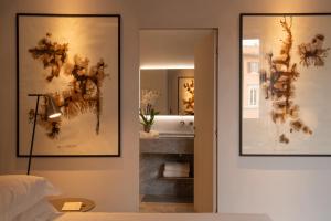 a bedroom with two pictures on the wall and a mirror at The Bank Hotel - Etruria Collection in Perugia +65 photos