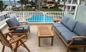 a couch and chairs on a balcony with a pool at Panoramic Views Two Decks 1st Row Ocean Kite Beach in Cabarete