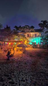 a beach with tables and umbrellas at night at Paradise beach homestay in Alleppey