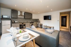 a living room with a couch and a table at Edgerton Stays in Huddersfield