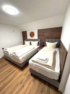 two beds in a small room with wood floors at Apartments Rosenstraße in Soltau