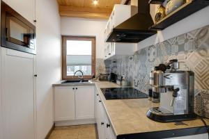 a kitchen with a coffee maker on a counter at Leśna Chata domek z balią in Sękowa +12 photos