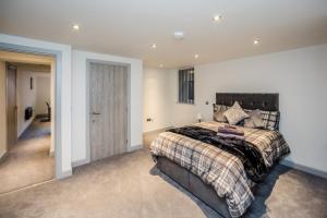 a bedroom with a large bed with a black headboard at Edgerton Stays in Huddersfield