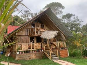 a small wooden house with a thatched roof at Cabaña Dos Búhos in Murillo