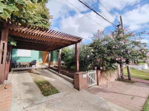 a wooden pergola on the side of a house at Casa Uruguay in Piriápolis