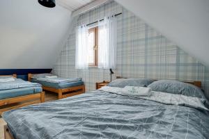a bedroom with two beds and a window at Leśna Chata domek z balią in Sękowa
