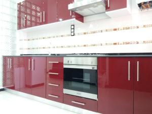 cocina con armarios rojos y fogones en Moderne Appart Tlemcen, en Tlemcen