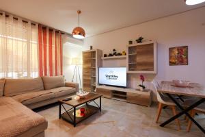 a living room with a couch and a flat screen tv at SanPietro Apartments in Draç