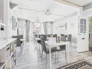 a dining room with white tables and chairs at Sorrento House in Blackpool
