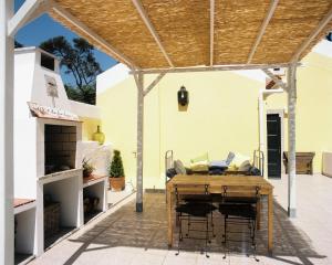 eine Terrasse mit einem Holztisch und einer Pergola in der Unterkunft The Five House in Sintra