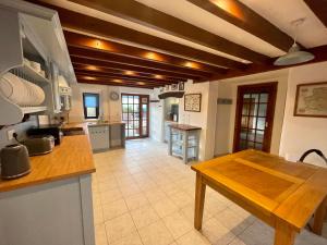 a kitchen with a wooden table in a room at Honey Meadow Retreat in Ashreigney
