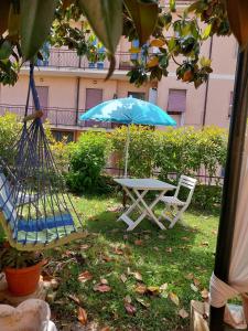 a picnic table and a blue umbrella in the grass at Eden casa vacanze in Morlupo